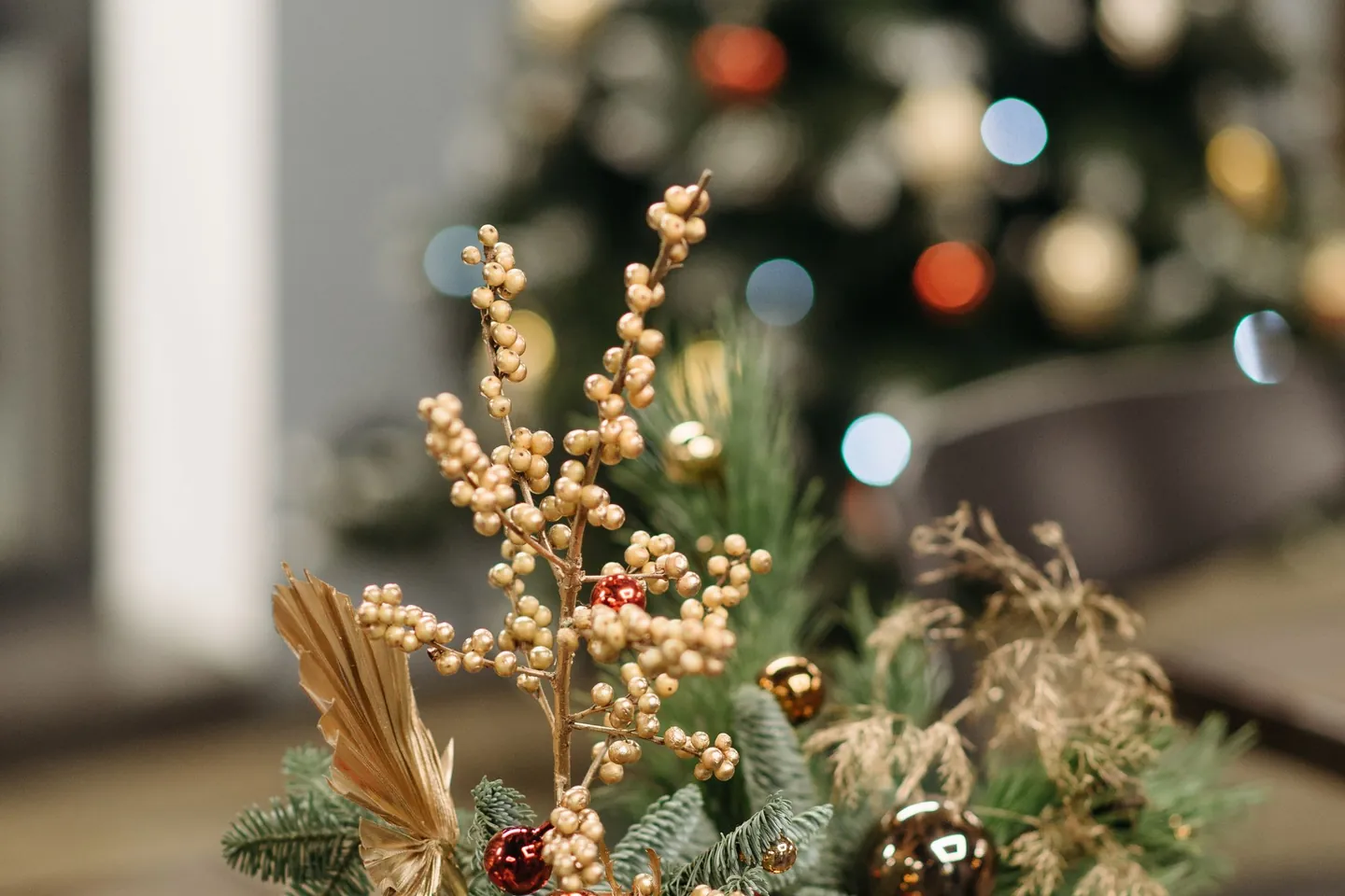 Gold and evergreen Christmas centerpiece on a coffee table.
