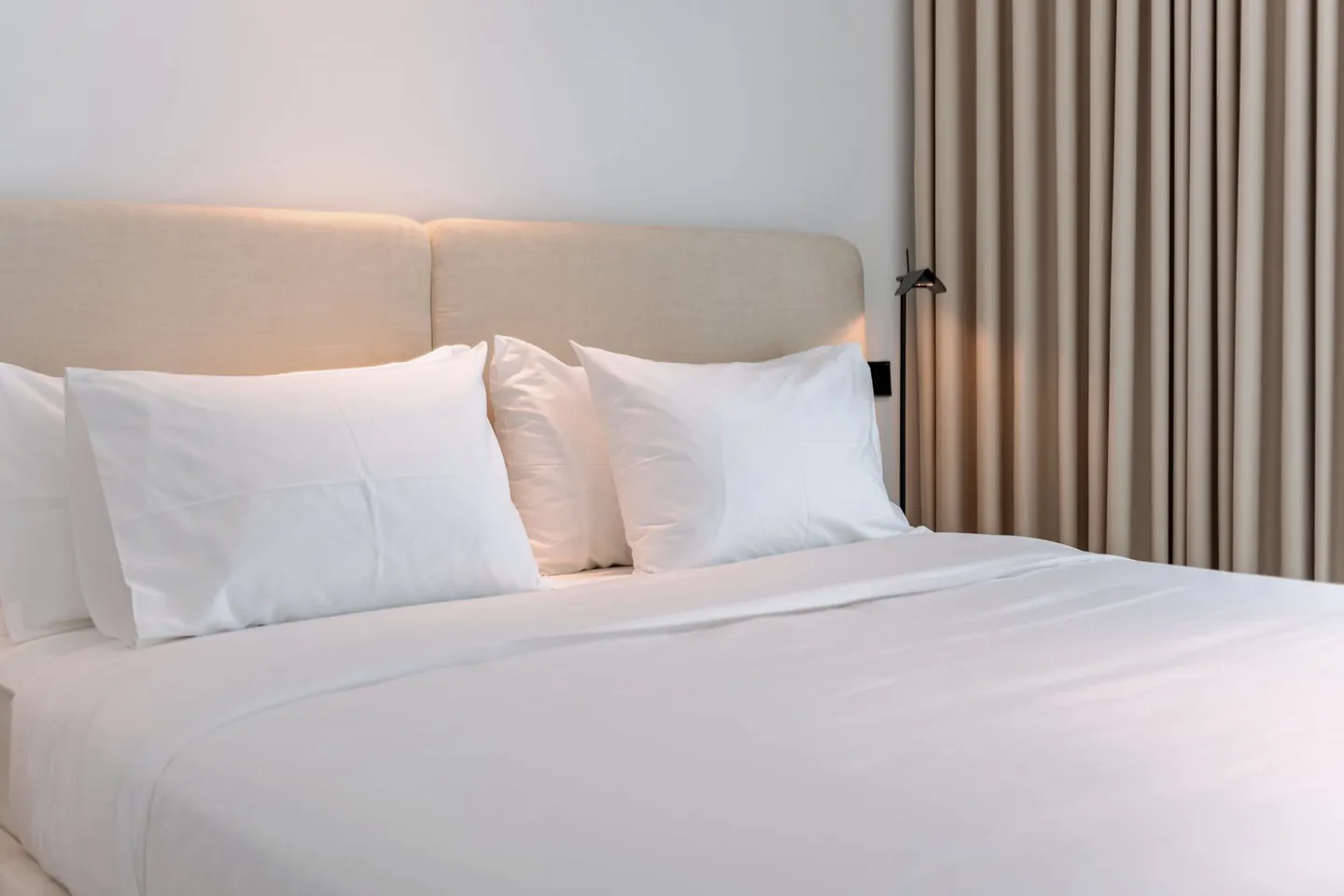 Soft neutral bedding in a modern beige bedroom.