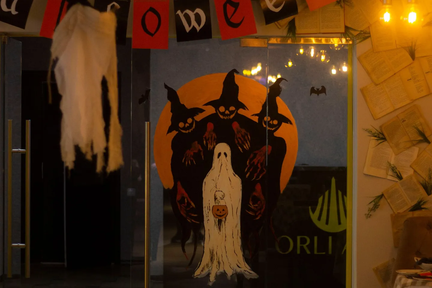 Halloween party room with dark decorations and orange lights.